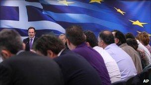 Greek Finance Minister George Papaconstantinou, seen behind journalists, speaks during a news conference in Athens on 23 November 2010