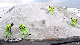Contractors work on a 27,000-tonne mound of marine salt in Dagenham