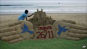 Indian sand artist Sudarshan Pattnaik gives finishing touches to a sand sculpture ahead of the second anniversary of the Nov. 26, 2008