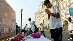 A man pays homage to those who died in the Mumbai attacks at a memorial outside the Taj hotel on 26 November 2010