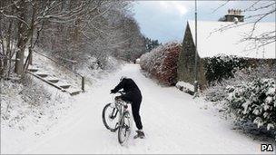 Man on bicycle in snow in Peebles, Scottish Borders