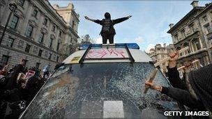 A student on a police van during the protest