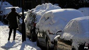 Woman clears snow from a car in Gateshead