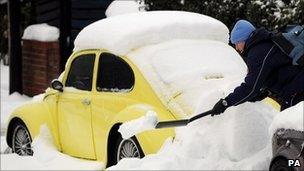 A man clears snow from his car