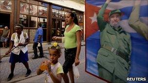 People walk past a poster of Fidel Castro on a bookshop window in Havana