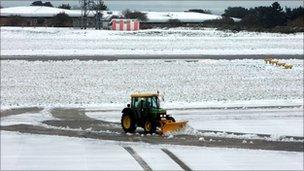 Tractor works on clearing snow from Guernsey Airport runway