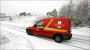 A Royal Mail post van struggles through the snow