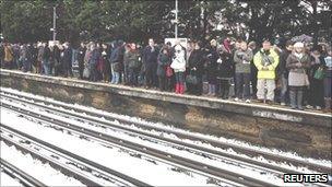 Commuters wait in the snow for a Tube train at Parsons Green station