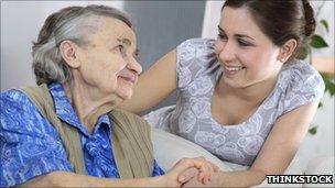 Woman caring for elderly woman (posed by models)