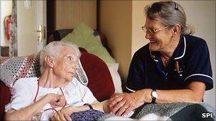 Smiling nurse talking to elderly patient