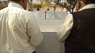 Relatives of Rashid and Sajid Emmanuel pray at their graves