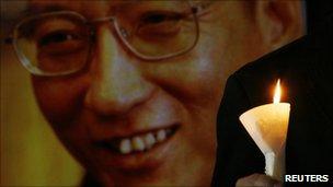 A protester holds a candle near a portrait of Liu Xiaobo at a vigil in Hong Kong