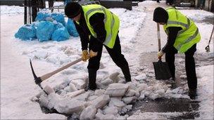 Men with pick axes clear snow