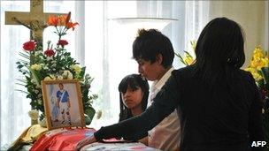 Relatives of murdered footballer Carlos Mercedes Vasquez mourn beside his coffin on 29 November 2010