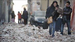 People walk on rubble in the centre of L'Aquila (April 6, 2009)
