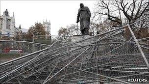 Collapsed metal barricades in front of a statue of William Churchill