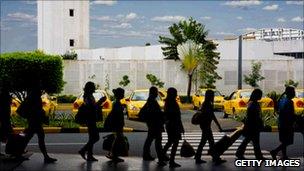 Travellers pull cases in an airport