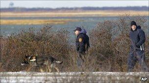 Police search along a road near Cedar Beach