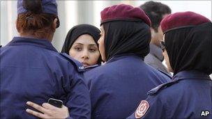 Police surrounding a female relative of one of the defendants