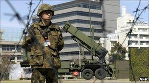 A Japanese soldier stands guard next to an interceptor missile launcher at the Defense Ministry headquarters in Tokyo