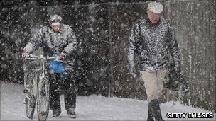 Walker and cyclist in snow