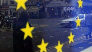 The European Union flag is reflected on a window