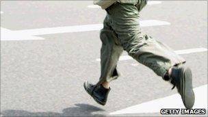 A man runs across the road