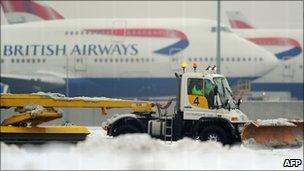 A worker operates a snow plough near the second runway at Heathrow