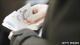 Hands holding a pile of sterling notes (Getty Images)