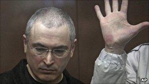 Mikhail Khodorkovsky listens to a verdict from behind bars at a court room in Moscow