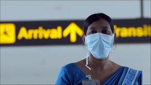 A Sri Lankan health official monitors passengers at the airport in June 2009