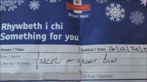 The note left by a postal worker says "parcel in green bin"