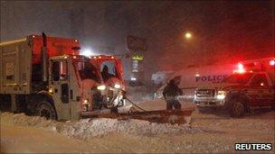 Snow plough digging out an ambulance