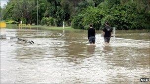 Two residents walk through floods in Emerald on 30 December 2010