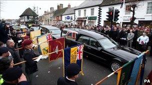 Mourners watch the hearse carrying Cpl Steven Dunn's coffin