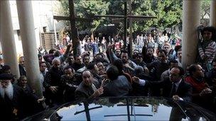 Protesters crowd round a vehicle carrying Egyptian Grand Imam of Al-Azhar Ahmed al-Tayeb at the al-Abasseya Cathedra in Cairo, 2 January 2011.