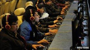 A man smokes while using a computer at an Internet cafe in Shanxi province