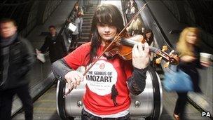 Olivia Shotton plays music by Mozart on her violin to commuters at Waterloo Underground Station