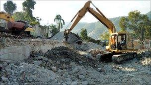 A digger clears rubble