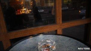 An ashtray stands on a table outside a bar in Madrid, 2 January