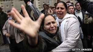 Egyptian Christians mourn outside the Al-Qiddissine church in Alexandria which was hit by a bomb attack on 1 January 2011