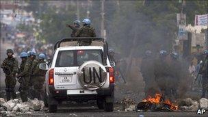 UN peacekeepers pass through a barricade set by protesters in Port-au-Prince, 10 December 2010.