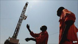 Two oil workers stand on the drilling site in Unity State, Southern Sudan on 11 November 2010