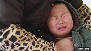 A child who was diagnosed with having excessive lead in his blood cries as he receives medical treatment at a hospital in Hefei, Anhui province