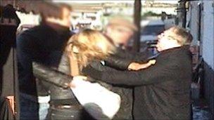 Reporter Sam Poling is helped by a 鶹Լ security guard (whose face is pixillated) as she is attacked by one of the cigarette sellers