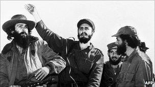 Cuban rebel leader Fidel Castro (centre), surrounded by the members of his leftist guerrilla movement "26th of July Movement" waves from a jeep 08 January 1959, entering La Havana