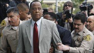 Conrad Murray accompanied by police officers