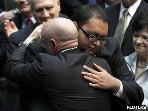 Daniel Hernandez is hugged by Rep Giffords' husband at the McKale Memorial Center in Tucson (12 January 2011)