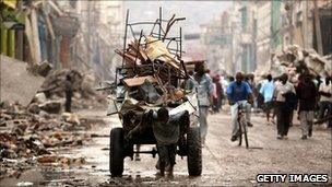 A child pulling rubble on a cart in Haiti