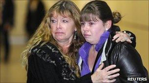 British passenger Lizzy Roe (R) is met and comforted by her Mother, Jill Roe, as she arrives from Tunisia at Gatwick Airport